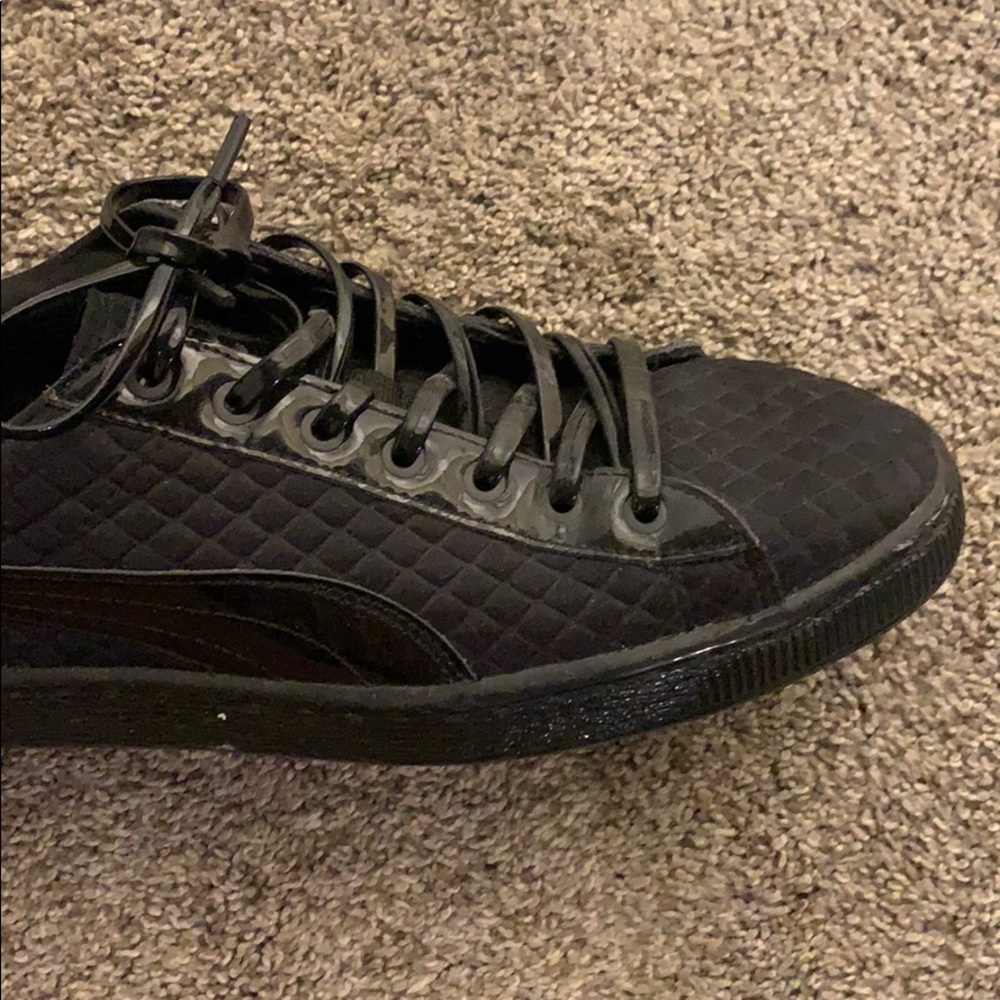 all black shiny puma sneakers.